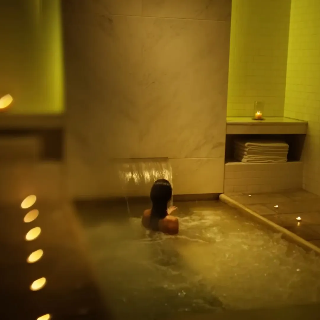 Woman relaxing in a candlelit thermal pool